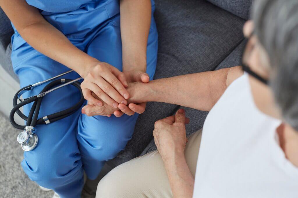 A Nurse Taking Hold of a Patients Hand - ViaQuest Hospice